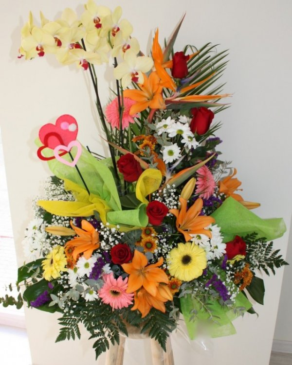 centro de flores variadas de colores con planta de orquídea