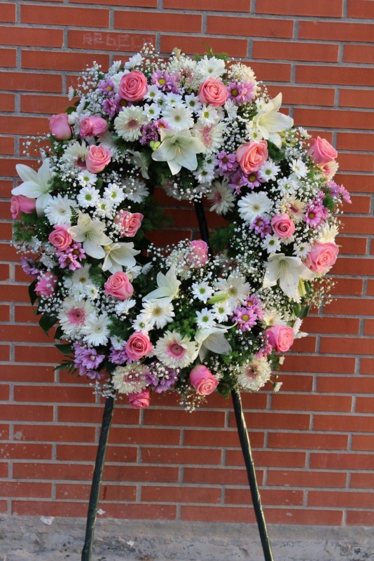 corona fúnebre de flores variadas con forma redonda