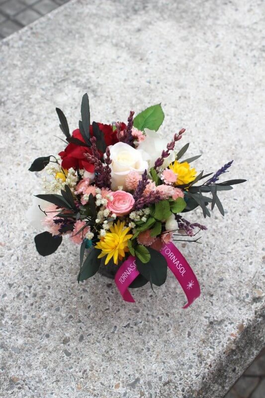 centro de flores de cerámica negra con flores preservadas
