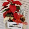 caja de madera con flor de pascua, un pino nebado y una lazada navideña