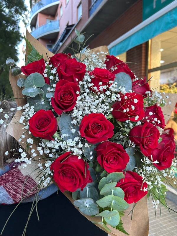 ramo de dieciocho rosas naturales con verdes decorativos que realzan la belleza del trabajo floral
